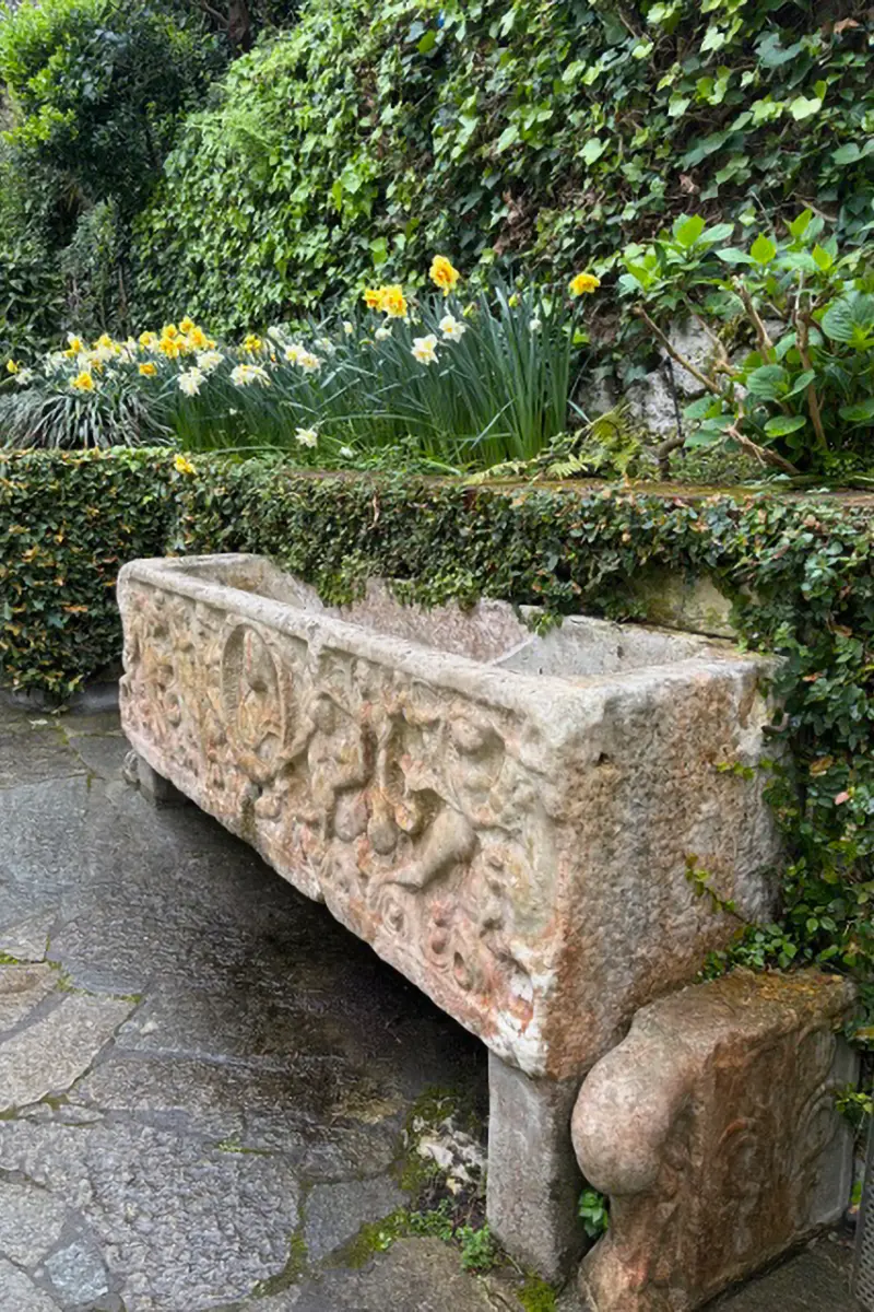 Typisch italienischer Steintrog als Dekoelement in einem Garten.