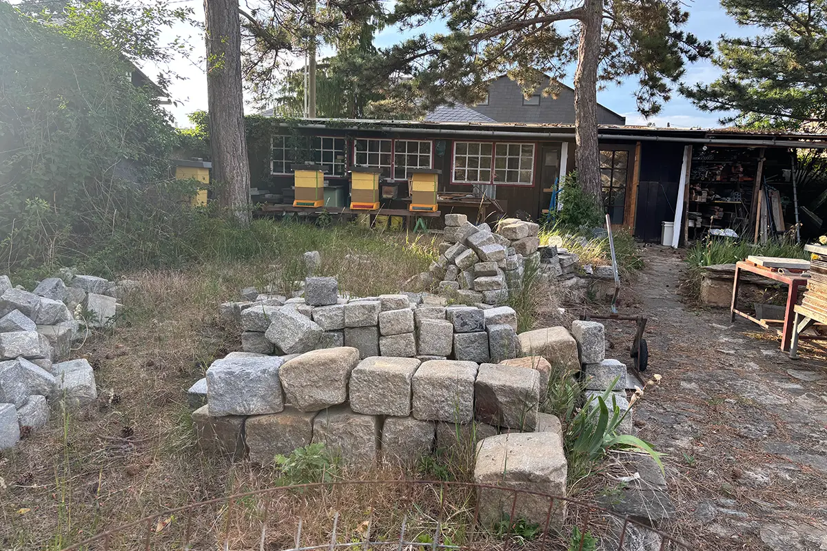 Garten mit großen Steinblöcken im Vordergrund.