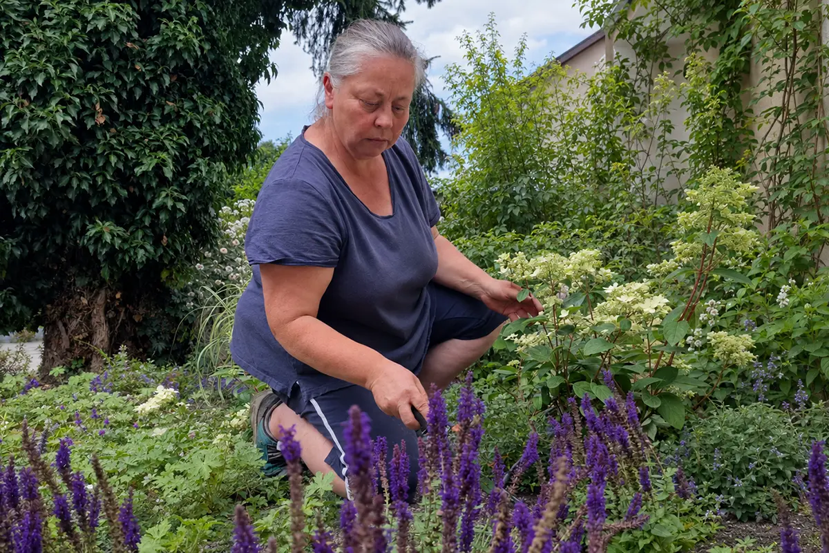Gartengestalterin Isabella Pfenning bei der Arbeit in einem blühenden Garten.